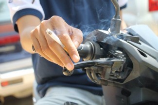 Naik Motor Sambil Merokok Bisa Kena Denda, Begini Aturan Hukumnya